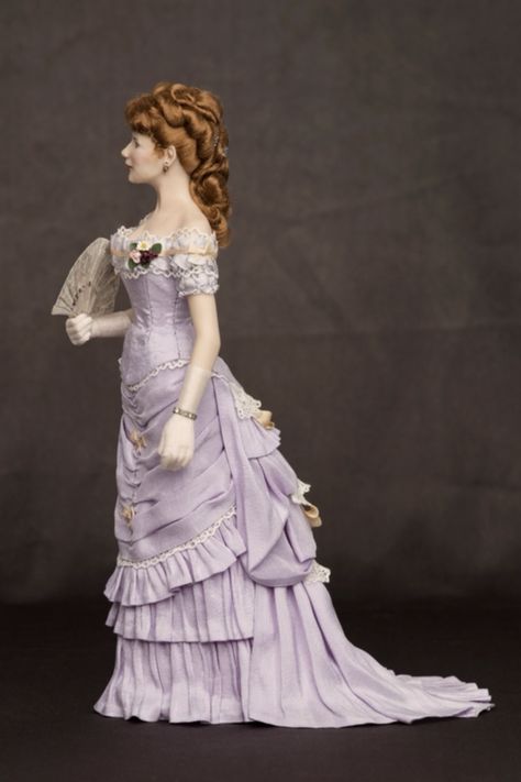 Lena: lady in a 1870s ball gown made out of lavender taffeta silk and adorned with drapes, lace and ribbons. The doll has a hand fan from the period made in collaboration with Cristina Noriega. Price of the doll: 1450 € November 2020. 1890s Ball Gown, 1870 Dress, Victorian Ballgown, 1870s Dress, Chicken Clothes, Victorian Era Dresses, 1870s Fashion, Victorian Hairstyles, 1800s Fashion