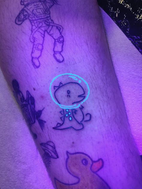 Dinosaur astronaut with UV ink Dinosaur In Space Tattoo, Dinosaur Astronaut Tattoo, Space Dinosaur Tattoo, Dinosaur Astronaut, Dinosaur Tattoo, Solar System Tattoo, Duck Tattoos, Helmet Tattoo, Astronaut Tattoo