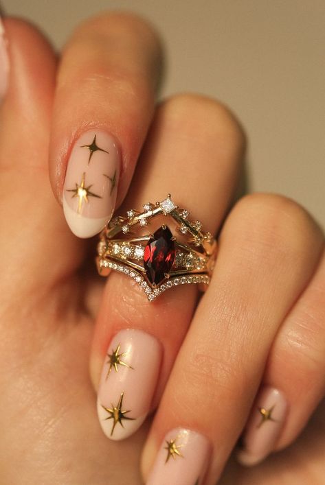 A woman's hand wearing a custom 3-piece wedding ring set from Staghead Designs. This 14K yellow gold ring set features an engagement ring with a marquise cut garnet center stone with claw prongs & round diamond accents & two contoured bands. The top band is V-shaped with princess cut diamonds that look celestial or like stars across the sky. The bottom band is V-shaped with pavé diamonds. This fully customizable set can also be made in 14K white or rose gold. 3 Part Wedding Ring, Alternative To Engagement Rings, Vintage Ruby Wedding Rings, Unique Ring Sets, Ruby Bridal Set, Garnet Marquise Ring, No Traditional Wedding Rings, Marquise Garnet Ring, Vintage Color Engagement Rings