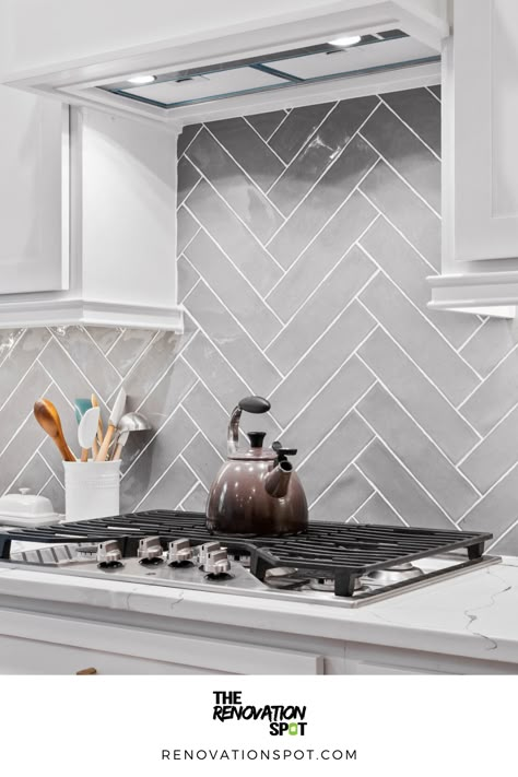 Kitchen Remodel by the Renovation Spot | Grey Herringbone Backsplash for White and Gold Kitchen Remodel | Modern Kitchen Design Grey Herringbone Backsplash Kitchen, Modern Grey Kitchen Backsplash, White And Grey Herringbone Backsplash, Light Gray Herringbone Backsplash, White Kitchen With Light Grey Backsplash, Kitchen Grey Tiles Wall, Kitchen Full Wall Tile, Dark Grey Herringbone Backsplash, Splash Back For Grey And White Kitchen