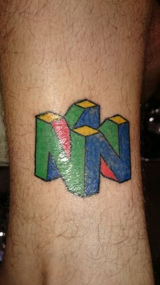 N64 logo on my left leg. It's still dry and shiny, and the colour is a bit patchy, but it was done by a close friend of mine who was still learning and I'm proud to have played a part in that. N64 Tattoo, Rob Tattoo, Tattoo Inspo, Pic Ideas, Tattoo Ideas, Video Games, Gaming Logos, ? Logo, Tattoos