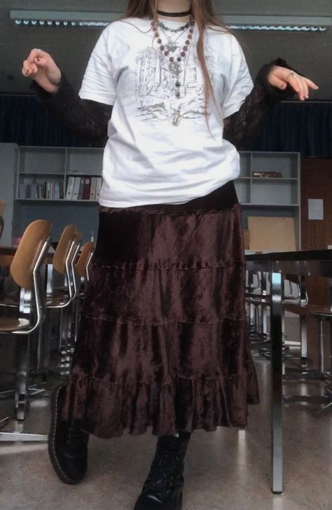 A mid-size person/girl wearing mate rose lipstick, a vintage graphic oversized shirt and a  black lace long sleeve underneath, a thrifted dark brown maxi skirt, black dr. Martens and multiple crystal rings and bracelets. The person is also wearing multiple silver necklaces, one in form of a butterfly and another in form of a moon, a rosary style crystal bead fairy necklace and a black lace choker. Alternative Maxi Skirt Outfit, Alt Maxi Skirt, How To Style A Long Brown Skirt, Outfits With Long Brown Skirt, Long Brown Skirt Outfit Aesthetic, Alt Maxi Skirt Outfit, Grunge Maxi Skirt Outfits, Brown Skirt Outfit Aesthetic, Long Brown Skirt Outfit