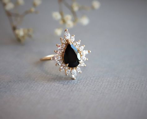 Another ✨NEW✨ beauty to share! The Lana in Black Onyx has long been a client favorite so we created another version, the Lana Pear, which features a stunning inky Black Onyx pear cut stone with a shimmering halo of Diamonds. 🖤 Black And Gold Jewelry, Black Onyx Engagement Ring, Onyx Engagement Ring, Black Onyx Ring, Onyx Gemstone, Jewelry Lookbook, Ring Black, Onyx Ring, Halo Ring