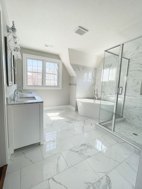 Master bathroom with affordable ceramic tile that looks like Carrara marble! Includes a soaking tub, glass vanity lights, multiple windows, large glass framed shower, and white double vanity. Carrera Bathroom, Colonial Bathroom, Marble Tile Bathroom, White Marble Bathrooms, Marble Floors, Large Bathroom, Master Bath Remodel, Bathroom Remodel Shower, Bathroom Remodel Designs