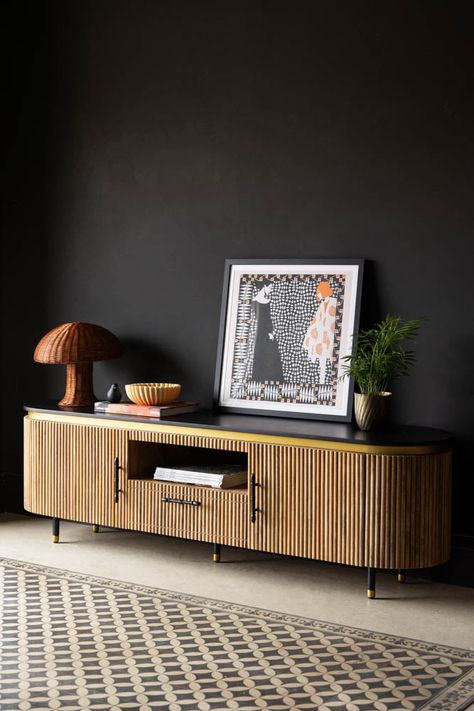 The Ribbed TV Unit styled in front of a dark wall, with an art print, plant, lamp and various other home accessories styled on top. Bohemian Tv Unit, Long Tv Unit, Mango Wood Bedside Tables, Beautiful Bedside Tables, Modern Chinoiserie, Wood Tv Unit, Kitchen Accessories Storage, Wood Bedside Table, Rockett St George