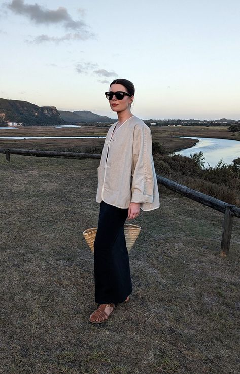 A woman stands on a hill in front of a river. She wears oversized sunglasses, a linen jacket, navy slip dress, basket bag and fisherman sandals. South Africa Outfits, Activewear Inspiration, South Africa Fashion, Outfit Ideas For Summer, Loose Vest, Farm Clothes, Summer Vacation Outfits, House Clothes, Early Autumn