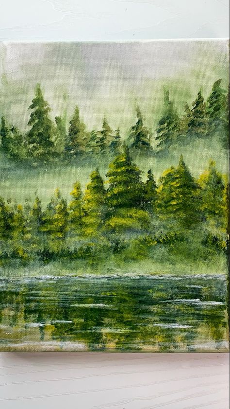 Foggy green pine forest painting with acrylic on canvas. There are two layers of pine trees with foggy mist. There is also a reflection of the pine trees on the lake near the forest Pine Tree Forest Painting, Forest Painting Tutorial, Tree Forest Painting, Foggy Forest Painting, Misty Forest Painting, Pine Forest Painting, Nature Drawing Ideas, Pine Tree Painting, Christmas Tree Forest