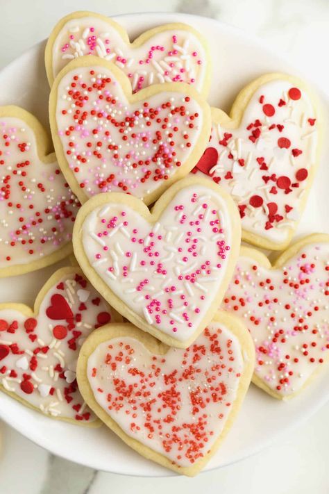 A large white plate with heart shaped sugar cookies with white icing glad red, white and pink sprinkles. Chocolate Pumpkin Tart, Heart Shaped Sugar Cookies, Pumpkin Tarts, Valentine Sugar Cookies, Holiday Sprinkles, Heart Shaped Cookies, Sugar Cookie Dough, Valentine's Day Recipes, Cookie Frosting