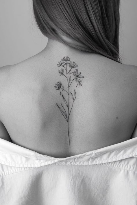 A single, dainty wildflower stem running vertically down the spine offers a sleek and elegant design. The minimal line work creates a graceful look that follows the natural curve of the body. It�s a stunning option for women who love vertical tattoos with a touch of nature. Texas Wild Flower Tattoo, Dainty Wildflower Tattoo, Vertical Tattoos, Wildflower Tattoo Ideas, Vertical Tattoo, Red Insects, Wildflower Crown, Dahlia Tattoo, Dna Tattoo