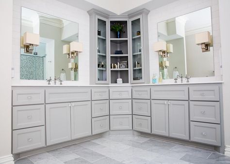 This remodeled bathroom features custom cabinetry with a tall corner unit for added, open storage. Sheet mirrors are backed by sleek white subway tile, with mirror-mounted sconces to provide task lighting. Glass hardware on the doors and draws adds glamour and sparkle. L Shaped Vanity, L Shaped Bathroom, Corner Bathroom Cabinet, Bathroom Corner Cabinet, Corner Bathroom Vanity, Corner Vanity, Dogs Instagram, Master Bath Vanity, Instagram Username