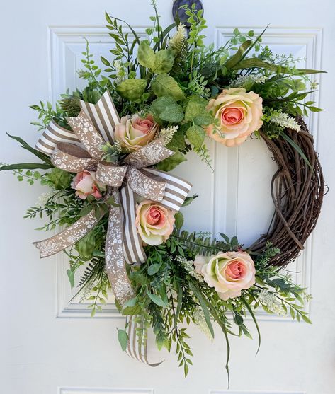 Welcome the beauty of spring and summer with this charming Floral Grapevine Wreath! This wreath bursts with the vibrant colors and fresh feel of the season. It features delicate roses, assorted greenery all beautifully arranged on a sturdy 18" grapevine base. The highlight of this wreath is a handcrafted bow made from premium wired ribbon, adding a touch of elegance. Perfect for your door, mantel, or any space that needs a splash of springtime joy, this wreath is sure to delight. Bring the essen Floral Grapevine, Outdoor Porch, Wired Ribbon, Spring Wreath, How To Make Bows, Wreaths For Front Door, Grapevine Wreath, Grape Vines, Spring Time