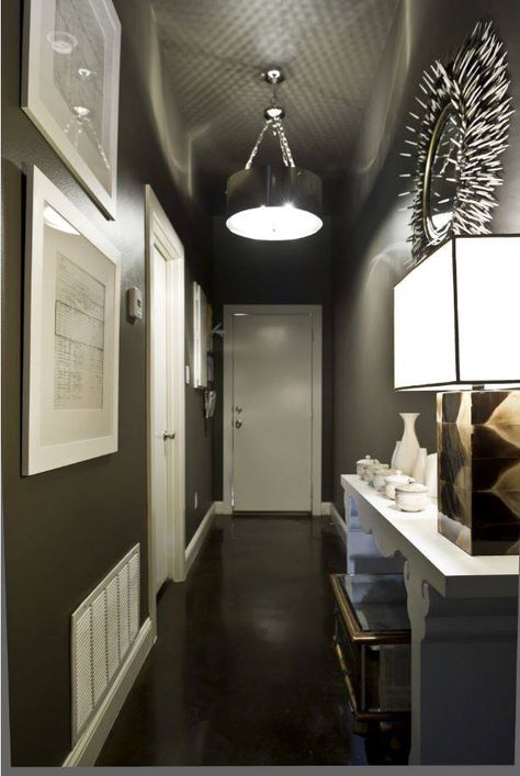 There’s no rule that says you have to paint a narrow hallway a light color. In fact, a dark hue adds drama and definition — especially when contrasted with white. To achieve the look pictured here, we suggest Black Oak KMA89 and Acoustic White 46. Hallway Paint Colors, Black Hallway, Grey Hallway, Hallway Paint, Design Hall, Small Hallway Ideas, Hallway Designs, Hallway Design, Dark Walls