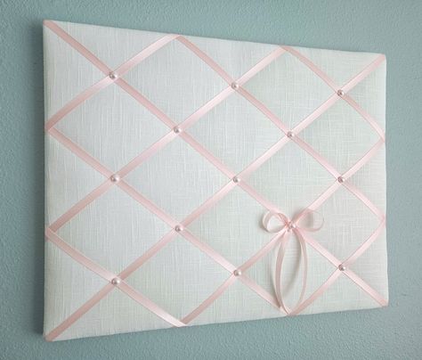 This delicate memo board in white linen fabric is accented with light pink satin ribbon and faux pearl details. Use it to display your photos, notes and cards, or just on its own as one of a kind soft wall hanging. Sizes: 20in wide x 16in tall (pictured) 24in wide x 18in tall 24in wide x 20in tall **Other sizes available, please contact me for details.** My memo boards and fabric pictures are carefully handcrafted using high quality materials, with generous batting. All my boards are light weigh Cork Board Covered In Fabric, Pink Cork Board, Memo Board Diy, Pin Board Ideas, Pink Linen Fabric, Bow Trend, Pink Dorm, White Linen Fabric, College Decor