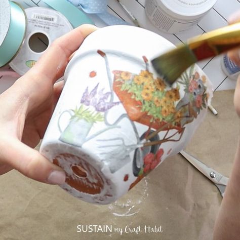 Learn how to apply a beautiful paper napkin design on to a clay pot with decoupage. Napkin Decoupage Flower Pot, How To Decoupage With Napkins, Decoupage Clay Pots, House Solarium, Clay Pots Crafts, Napkin Decoupage Ideas, Decoupage Pots, Bathroom Beadboard, Canister Crafts