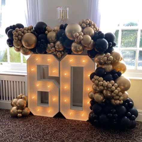 Light up 60 teamed with an organic balloon garland in black and chrome gold. Venue - @hotelmiramarbournemouth This combo is still a firm favourite with you all 🤩 #balloondisplay #balloondisplayideas #balloons #balloonstylist #balloonsdecor #balloonsdecoration #balloonsforalloccasions #balloons🎈 #balloonsofinstagram #light #up #numbers #light #up #numbers #lightupnumbers #60thbirthday #60thbirthdaycelebration #bapiaparty #blissfulballoonz #balloons2buisness #sempertex #kalisan #kalisanball... 60 Balloon Arch, Balloon Arch With Numbers, 60 Marquee Numbers With Balloons, Balloon Garland With Marquee Numbers, Balloon Wall With Marquee Numbers, Black Gold Balloon Ring, 60 Balloons, 30 Balloons, Theme Pictures