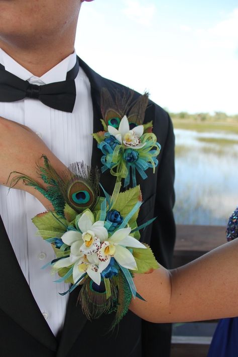 Corsage With Orchids, Unique Boutineer Ideas Prom, Peacock Prom Flowers, 2023 Prom Bouquets, Peacock Feather Corsage Prom, Prom Corsage And Boutonniere 2023, Peacock Feather Corsage, 2023 Prom Flower Trends, Feather Corsage Prom