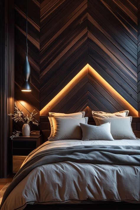 A chevron wood-patterned bedroom accent wall adds structure and movement to the room while keeping the design moody. Deep-stained wood in espresso, ebony, or walnut tones works well for modern bedroom accent wall ideas, giving the space a sleek yet cozy feel. This design pairs beautifully with soft lighting, leather furniture, and minimalist decor.