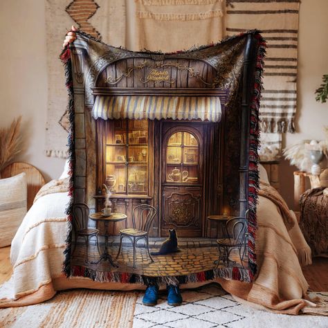 Add a touch of nostalgia to your home with our Cozy Vintage Coffee Shop Blanket. This beautifully designed throw features a charming vintage coffee shop scene that will transport you to a quaint street corner filled with warmth and character. Whether draped over your couch or spread on your bed, this blanket is sure to add a cozy and inviting feel to any room. Made with attention to detail, it captures the essence of a rustic, old-world coffee shop, complete with a striped awning, classic bistro chairs, and a black cat lounging on the cobblestone street. The soft hues and intricate details make it a standout piece that complements various interior styles, from traditional to contemporary. Not just a decorative item, this blanket is functional and versatile. It provides the perfect amount o Shop Blanket, Striped Awning, Cat Lounging, Vintage Coffee Shops, Cobblestone Street, Living Room Unique, Cat Lounge, Street Corner, Room Unique