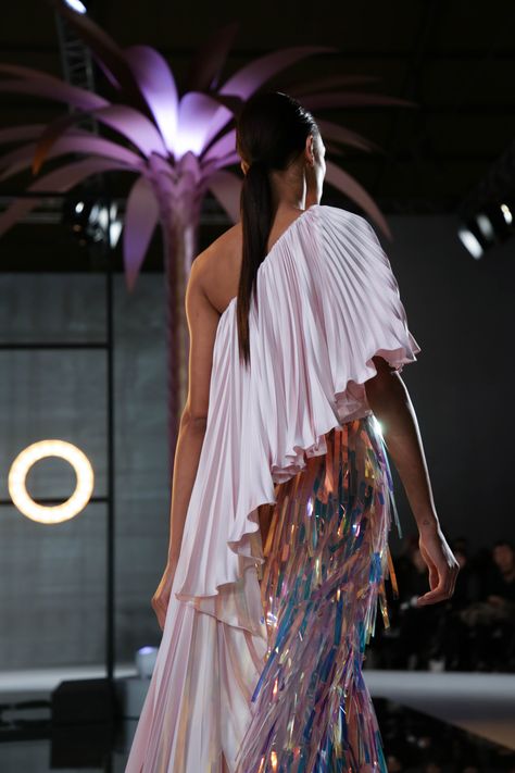 #Blush #pink #asymmetrically #draped #jumpsuit, featuring a double #satin sunray pleated top and chiffon #trousers embellished with iridescent #laminated #fringing. Iridescent Pleated Dress, Designer Draped Sequin Sets, Draped Outfits Runway, Luxury Voluminous Pleated Draped Skirt, Feather Runway Fashion, Holographic Dress, Dolly Fashion, Pink Inspiration, Draped Top