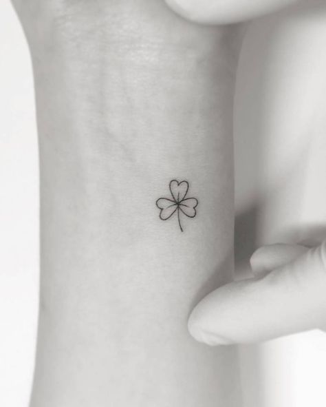 Clover tattoo located on the wrist, minimalistic style. Small Shamrock Tattoo Irish Simple, Minimal Shamrock Tattoo, Shamrock Wrist Tattoo, Shamrock Vine Tattoo, Minimalist Shamrock Tattoo, Clover Outline Tattoo, Shamrock Fine Line Tattoo, Simple Shamrock Tattoo, Dainty Shamrock Tattoo