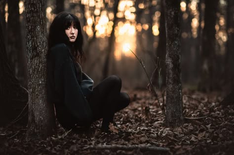 a goth high school senior leans against a tree in the woods at sunset for moody senior photos Spooky Senior Photos, Senior Portrait Inspiration, Dark Forest Senior Pictures, Horror Senior Pictures, Moody Senior Portraits, Gothic Graduation Pictures, Gothic Senior Photos, Moody Senior Photos, Senior Photo Shoot Poses