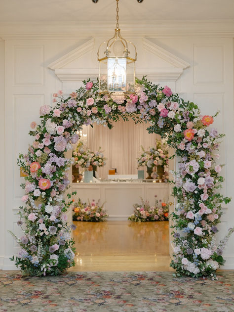 Create a stunning first impression with this elegant floral entrance arch. Adorned with lush blooms in shades of pink, lavender, and peach, this archway sets the perfect tone for a romantic and enchanting event. #FloralEntrance #WeddingDecor #RomanticWedding #FlowerArch #ElegantEvent #WeddingInspiration Entrance Arch Wedding, Tangled Prom, Floral Entrance, Backdrop Setup, Flower Archway, Lavender And Peach, Wedding Gate, Entrance Arch, Reception Styling