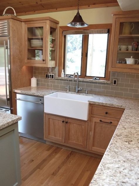 Ideas to update an oak kitchen by adding glass to the solid doors. Shown with granite top and apron front sink. Photo via Zillow, design by Robert Adam Dorn Kitchen With Wooden Cabinets, Craftsman Kitchen, Kabinet Dapur, Herringbone Backsplash, Oak Kitchen Cabinets, Farmhouse Kitchen Cabinets, Tiles Kitchen, Kitchen Paint Colors, Farm Kitchen