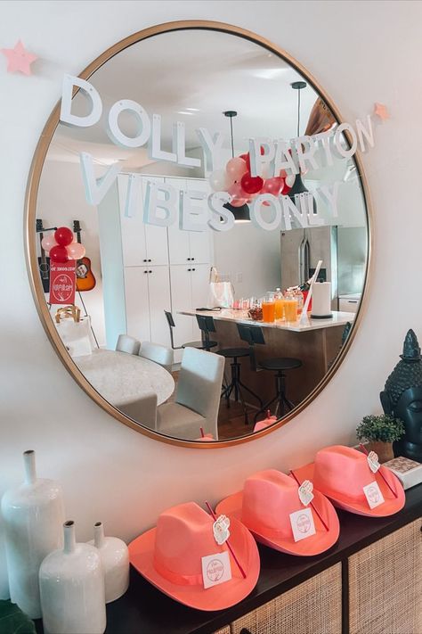 pink cowgirl hats, Dolly Parton vibes only, Dolly Parton bachelorette party, bachelorette party decor, pink balloons, sign hanging over mirror in living room Nashville Bachelorette Party Dolly Parton, Dolly Parton Birthday Party Decorations, Dolly Themed Bachelorette Party, Dolly Parton Themed Bachelorette Party, Dollywood Bachelorette, Dollywood Bachelorette Party, Dolly Bachelorette Party, Dolly Parton Party Theme, Dolly Parton Birthday Party Theme