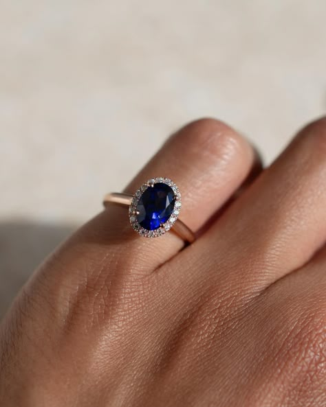 There’s something about that blue against the rose gold 💙 this regal engagement ring has a gorgeous blue sapphire centre, a bold halo, and a soft round profile rose gold band. Details: - 1ct oval blue sapphire - 18x round moissanites - 18k rose gold - 1.9mm wide shank #customengagementring #nz #aus #sapphireengagementring #bluesapphirering #bespokeengagementring Sapphire Engagement Ring With Band, Oval Blue Sapphire Ring, Oval Solitaire Sapphire Ring, Saphire Engament Ring Gold Band, Blue Sapphire Rings Engagement, Regal Engagement Rings, Round Sapphire Ring, Sapphire Ring Gold, Oval Sapphire Engagement Ring