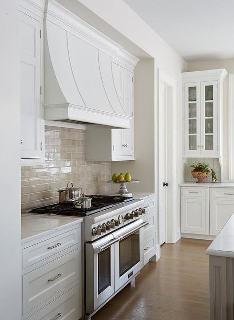 The taupe subway tile backsplash adds balance and energy to an otherwise neutral kitchen. Countertop Concrete, Tile Backsplash Kitchen, Neutral Backsplash Kitchen, White Wood Paneling, Kitchen Hood Design, Taupe Kitchen, Backsplash Design, Subway Tile Backsplash Kitchen, White Kitchen Backsplash