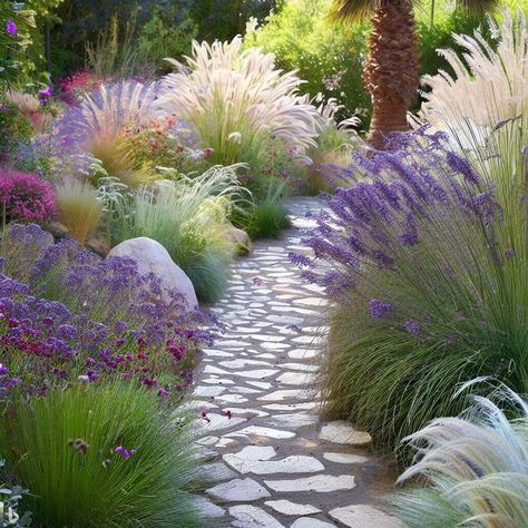 a charming mediterranean stone path: Tulbaghia violacea (Society Garlic) Agapantus, Stipa tenuissima (Mexican Feather Grass), Dietes Iridioides (Fortnight Lily), Armeria maritima (Sea Thrift), Lavandula stoechas "Anouk", (Spanish Lavender), Lavandula x intermedia "Provence" (Lavender) Grass And Lavender Borders, Mediterranean Flower Garden, Lavender And Lemongrass Landscaping, Heather Planting Ideas, Mediterranean Shade Garden, Lavender Planting Ideas, Mediterranean Planting Scheme, Salvias In The Garden, Modern Mediterranean Garden Design