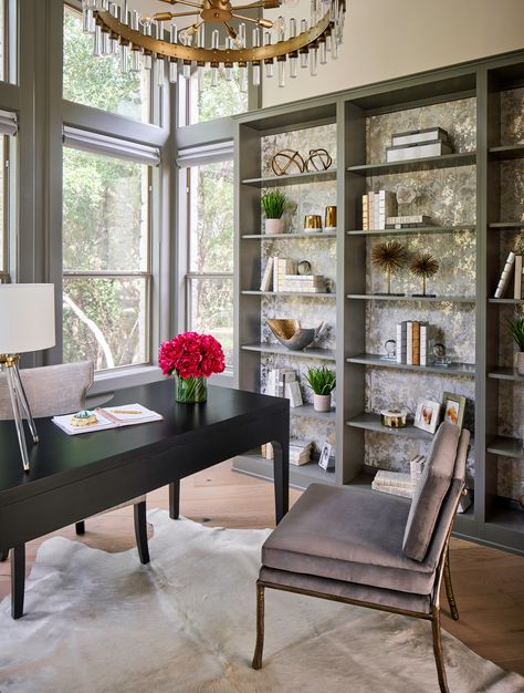 This stunning home office is part of a whole house remodel by Haven Design and Construction.  The Chelsea Gray Walls provide beautiful contrast against the green trees outside.  The light filled room is accented with gray velvet guest chairs featuring a twig design on the back.  The bookcase wall features bookcases accented with a gorgeous metallic vine wallpaper. Wallpapered Bookshelves, Painted Woodwork, Transitional Home Office, Fossil Creek, Toronto Interior Design, Dining Room Accents, Accent Wall Paint, Bookcase Wall, Paper Moon