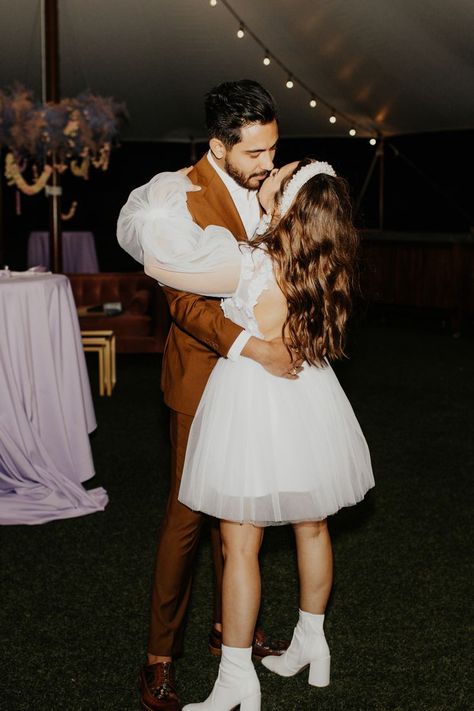 A short dress at your reception is SO cuuuuteee!!! Not that everyone wants to or certainly needs to do an outfit change, but we did think this bride was looking adorable in this short dress with sleeves similar to her wedding gown and the little go-go short style white boots! If you're into it, we say GO FOR IT! And then dance the night away. Short Wedding Dress With Boots Vintage, Short Wedding Dress With Booties, Bride White Boots, Bride In White Boots, 70s Bridal Outfit, Wedding Exit Outfit Casual, Unique Reception Dress For Bride, Romantic Reception Dress, Eclectic Wedding Dress Short