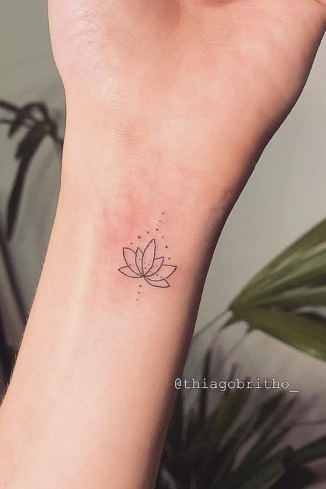 Discover unique and beautiful wrist tattoo ideas for women that wrap around the wrist effortlessly. Explore delicate and meaningful wrist tattoos to adorn your skin with grace and style. Whether you're looking for floral designs, minimalist symbols, or intricate patterns, these wrist tattoo ideas are perfect for expressing your individuality in a subtle yet artistic way. Minimal Lotus Tattoo, Lotus Flower Tattoo Wrist, Lotus Flower Tattoo Meaning, Tattoo On The Wrist, Small Lotus Tattoo, Meaningful Wrist Tattoos, Lotus Flower Tattoo Design, Wrist Tattoo Ideas, Flower Wrist Tattoos