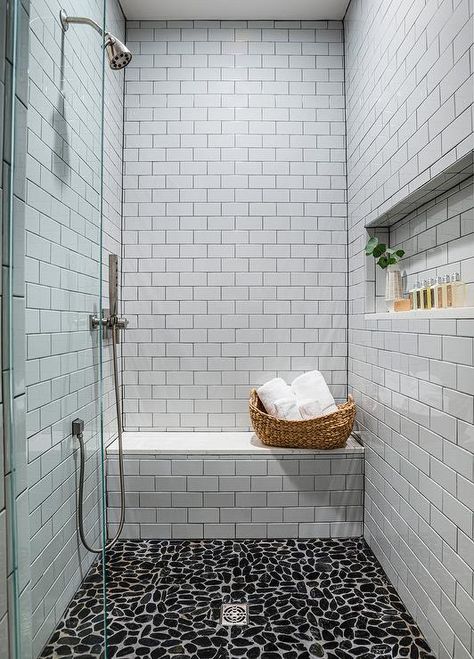 Black river rock tiles accent a walk-in shower boasting a white subway tiled bench and white subway surround tiles framing a rectangular niche fitted opposite a chrome shower kit. Subway Tile Shower Niche, Shower Floor Tiles, River Rock Tile, Stone Shower Floor, River Rock Shower, Black River Rock, White Subway Tile Shower, Tile Shower Niche, Rock Shower