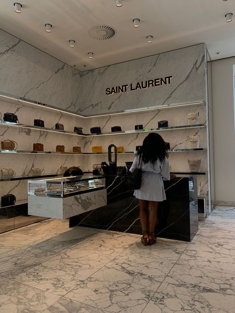 Woman standing in a room with luxury bags at the counter. She is shopping and waiting for her bag. Rich Girl Asthetic Black, Luxurious Lifestyle Black Women, Luxury Clean Girl Aesthetic Black Women, Rich Girl Aesthetic Black Women Vision Board, Luxury Life Black Women, Blackgirl Luxury Aesthetic, Shopping Aesthetic Black Woman, Faceless Luxury Aesthetic, Rich Girl Black Aesthetics