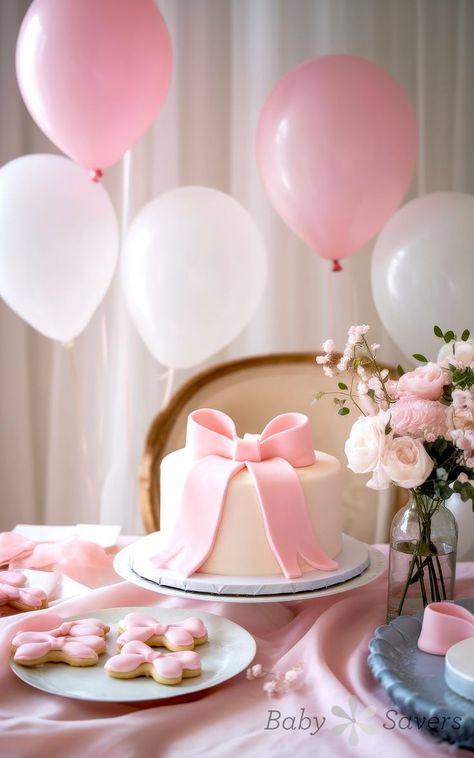 A beautifully decorated table showcases a white cake with a large pink bow, perfect for baby shower ideas. It's surrounded by pink and white balloons, with cookies shaped like bows on a plate. A vase of pink and white flowers completes the elegant and festive setup. Unique Baby Shower Ideas, Coquette Theme, Enchanted Forest Baby Shower, Bow Theme, Unique Baby Shower Themes, December Baby, Bow Baby Shower, Cowboy Baby Shower