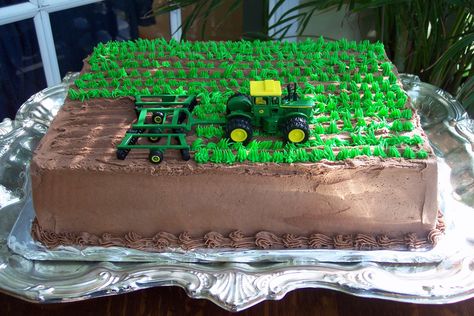 This chocolate cake has rows of crops that a John Deere Tractor is plowing. All in a days work for this groom. Tractor Birthday Cakes, John Deere Cake, John Deere Birthday Party, Farm Birthday Cakes, 4de Verjaardag, John Deere Birthday, Tractor Cake, Tractor Birthday Party, Farm Cake