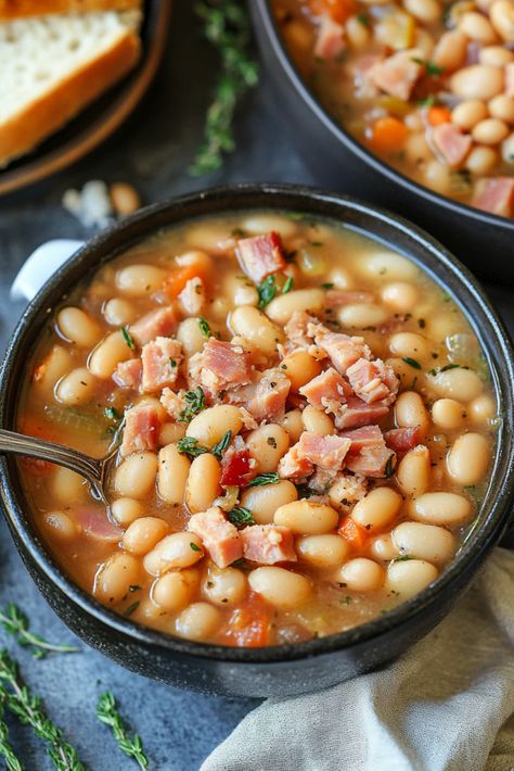 Crockpot Ham and Bean Soup is the ultimate comfort dish for chilly days, boasting rich flavors from a ham bone and beans. This easy dinner requires less than 10 minutes of active preparation. A slow cooker soup is a surefire delight on a frosty day—simply combine the ingredients in the crockpot and let the inviting Ham Bean Soup Crockpot, Ham Bone And Beans, Ham Soup Crockpot, Crockpot Ham And Bean Soup, Ham Bone Bean Soup, Stock Pot Recipes, Bean Soup Crockpot, Ham Bone Recipes, Crockpot Ham And Beans