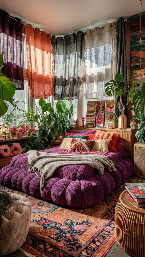 A boho-inspired bedroom with purple accents, layered throws, textured pillows, macramé wall hangings, and potted plants. White walls and a purple area rug complete the eclectic and cozy vibe. Purple Jewel Tone Bedroom, Bohemian Jungle Bedroom, Emerald Green And Orange Bedroom, Purple Green Room Aesthetic, Earthy Maximalist Bedroom, Room Decor Bedroom Purple, Purple And Red Bedroom, Blue Purple Room, Bedroom With Purple Accents