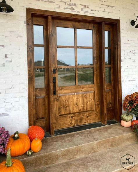 Rustica | Custom Doors + More on Instagram: “This doorway is giving us the perfect fall vibes! 🍂 Have you decorated your front porch yet? . . . #frontdoor #frontdoorinspo #porchgoals…” Knotty Alder Front Door With Sidelights, Modern Farmhouse Fiberglass Front Door, Rustic Front Door With Sidelights, Country Doors Farmhouse, Stunning Front Doors, Extra Wide Front Door Entrance, Coastal Farmhouse Front Door, Oversized Front Door Farmhouse, Barndominium Front Doors