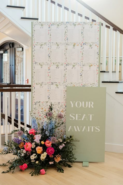 Seating chart wall display with flowers for a spring wedding. Photographer: Pearl Paper Studio Florist: Strange Vine Seating Chart Wedding Garden, Wooden Arch Seating Chart, Table Number Ideas Seating Charts, Unique Wedding Seating Chart Display, Spring Seating Chart, Floral Wedding Seating Chart, Seating Chart Garden Wedding, Photo Display Ideas For Wedding, Wedding Seating Chart Flowers