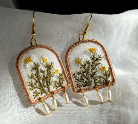 White daisies This pair of earrings were my first creation of the flower collection. The end pearls are gentle tingling on the bottom. Comfortable small size and it is very light weight. Daisies have been around for a very long time. The ancient Egyptians grew them in their gardens for herbal remedies. Many people believed that eating daisies could help ease stomach ulcer pains, gout and fever. What do daisies symbolise? •Innocence and purity •New beginnings •True love #embroidery #whi... How To Embroider Earrings, Embroidery Earrings Handmade Jewelry, Hand Embroidered Jewelry, Embroidery Earrings, Diy Fabric Jewellery, Simple Hand Embroidery Patterns, Love Embroidery, Small Embroidery, Embroidered Jewelry