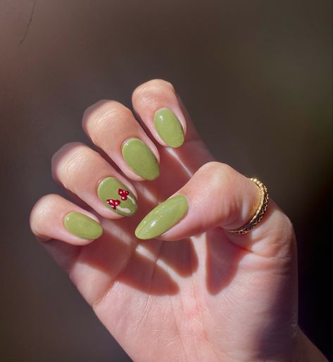 sage green nail with red mushroom design on ring finger Sage Green Mushroom Nails, Green Nails With Mushrooms, Orange Mushroom Nails, Almond Nails Mushroom, Cute Cottagecore Nails, Easy Nail Art Green, Mushroom Nail Art Acrylic, Cute Mushroom Nail Designs, Forestcore Nails