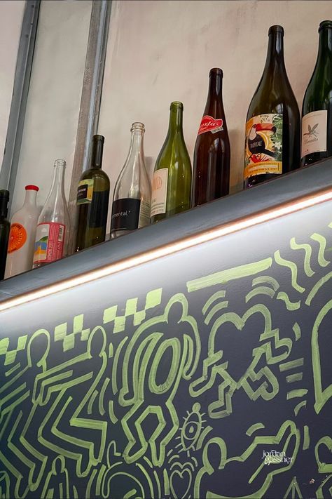 A shelf full of empty wine bottles above a wall with a green and blue mural at Tricky's in Lisbon, Portugal Clubs In Lisbon, Lisbon Bars, Restaurants Lisbon, Lisbon Wine Bar, Wine Portugal, Lisbon Restaurants, Lisbon Nightlife, Lisbon Restaurant, Lisbon Guide