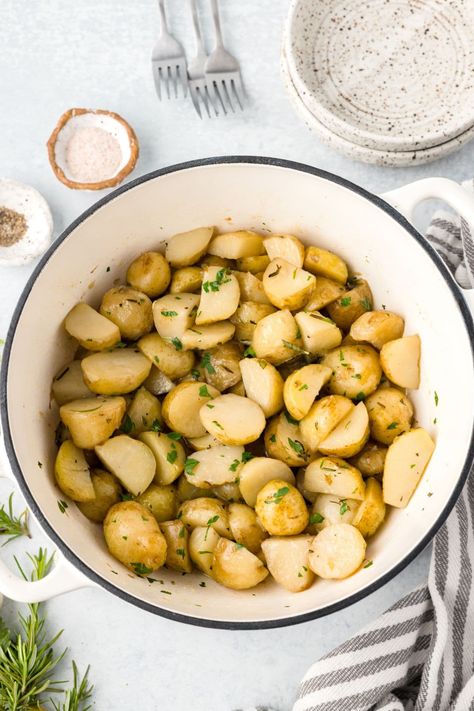 Sliced, herbed potatoes in a large white dutch oven surrounded by a linen and fresh herbs. Dutch Oven Potatoes Recipes, Potatoes Stovetop, Stove Top Potatoes, Dutch Oven Potatoes, Oven Potatoes, Baby Potato Recipes, Herbed Potatoes, Cooked Potatoes, Italian Potatoes