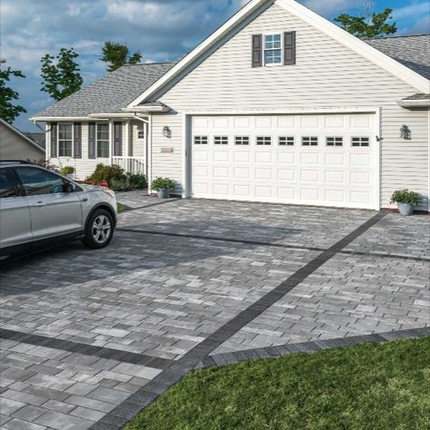 The owners of this property needed a parking solution that wouldn’t impede access to their garage. Unlike a large expanse of asphalt or concrete, which would have visually overwhelmed this modest home, a unique design utilizing Artline proved to be the perfect fit. Geometric bands in a contrasting color were created using Series in Black Granite, to add visual interest and define the driveway from the adjacent parking pad and front walkway. #Driveway #Entrance #Contemporary #Artline #Series Driveway Parking Pad Ideas, Driveway Patio Combo, Paver Parking Pad, Parking Pad In Front Of House, Parking Pad Ideas, Driveway Layout, Driveway Expansion, Modern Pavers, Driveway Extension