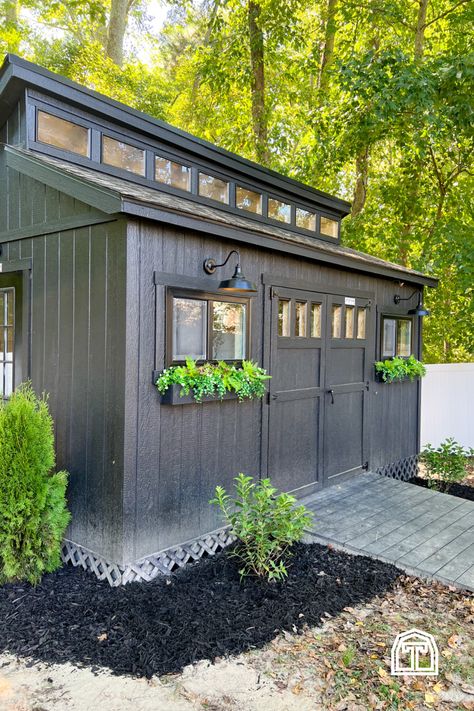 We love this modern shed workshop! There's charm inside and out of Cass' woodworking and DIY workshop shop, and it's filled with so many personal customizations and DIY design ideas. With an all-black paint scheme and bright exterior lighting, these beautiful shed design ideas make for a perfect backyard workshop shed. Add the space you need for DIY projects and infuse your style into your new backyard shed with inspiration from this modern shed workshop, filled with storage ideas and designs. Small Workshop Shed Ideas, Around The Shed Landscaping, Shrubs Around Shed, Shed With Planter Boxes, Black Outdoor Shed, Shed Addition To House, Outdoor Buildings Storage Sheds, Attached Shed To House, Custom Sheds Ideas