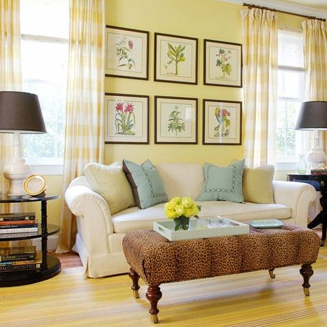 Light buttercream yellow unites this large living room. It starts on the walls and echoes in the gingham curtains and the striped rug. The lighter yellow backdrop allows yellow wall decor and a lively animal print on the ottoman to take center stage. Adding black accents will give a yellow room more zing. Just be careful not to add so much black that you mimic the decorating equivalent of a bumblebee. Buttercream Walls, Living Room With Yellow Walls, Room With Yellow Walls, Yellow Living Room Colors, Pale Yellow Walls, Yellow Walls Living Room, Yellow Wall Decor, Yellow Room, Yellow Living Room