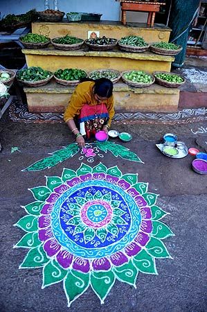 An Indian woman applies coloured powder to her "rangoli", a Hindu ritual design, in front of her house in Hyderabad on January 1, 2013. Rangolis are drawn in front of homes early in the morning with a beautiful motif to welcome relatives and friends to mark the New Year. — AFP Photo. "Repinned by Keva xo". Yoga Studio Design, Hindu Rituals, Colored Chalk, Celebration Around The World, Sidewalk Chalk Art, Rangoli Patterns, Indian Patterns, Early In The Morning, Sidewalk Chalk